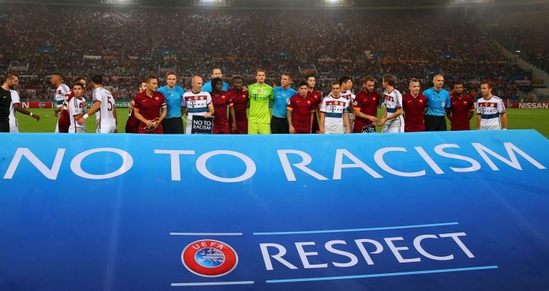 Los jugadores de la Roma y el Bayern, con una pancarta contra el racismo y por el respeto de la UEFA.