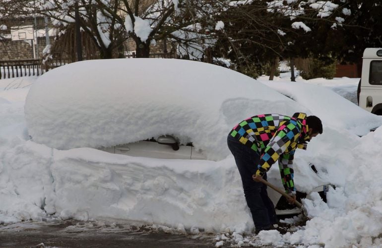 Un vecino del pueblo de Felechosa, perteneciente al Concejo de Aller, retirando nieve de un vehículo.