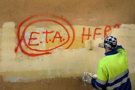 Un trabajador municipal pinta sobre el graffiti leyendo &quot;ETA, El pueblo está contigo&quot; en Gernika, un día después de que el grupo separatista vasco ETA anunciara un cese definitivo de la actividad armada.