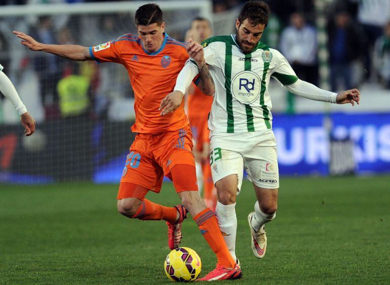 Valencia&#039;s Argentinian midfielder Rodrigo de Paul (L) vies with Cordoba&#039;s defender Eduard Campabadal (R) during the Spanish league football match Cordoba CF vs Valencia CF at The Nuevo Arcangel stadium in Cordoba, on February 21, 2015. AFP PHOTO / CRISTINA QUICLER