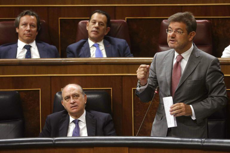 El ministro de Justicia, Rafael Catalá (d), en presencia del ministro del Interior, Jorge Fernández Díaz (i), durante su intervención en el pleno que se celebra en el Congreso de los Diputados. EFE/Javier Lizón