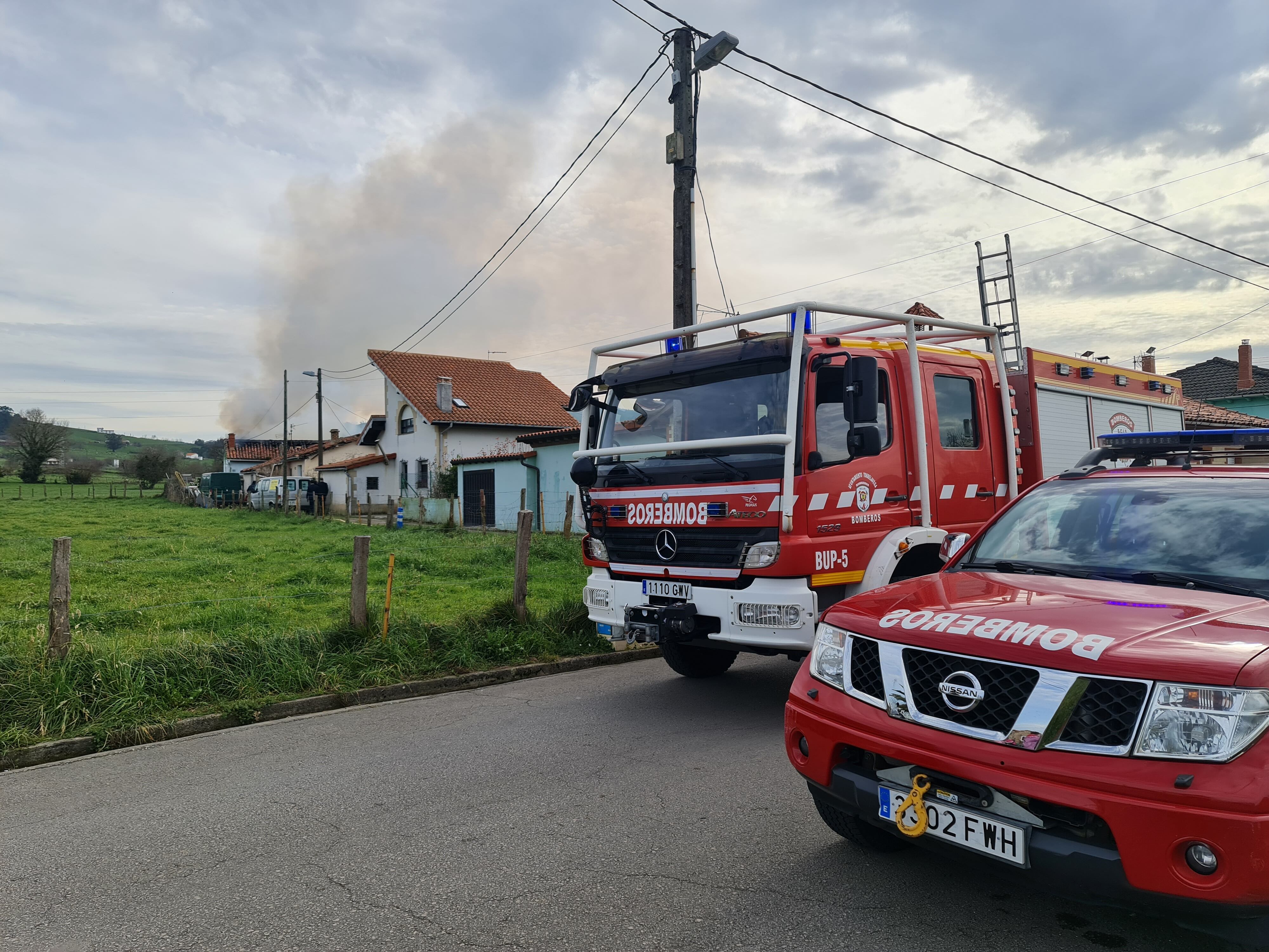 Vehículos de bomberos frente a la vivienda afectada