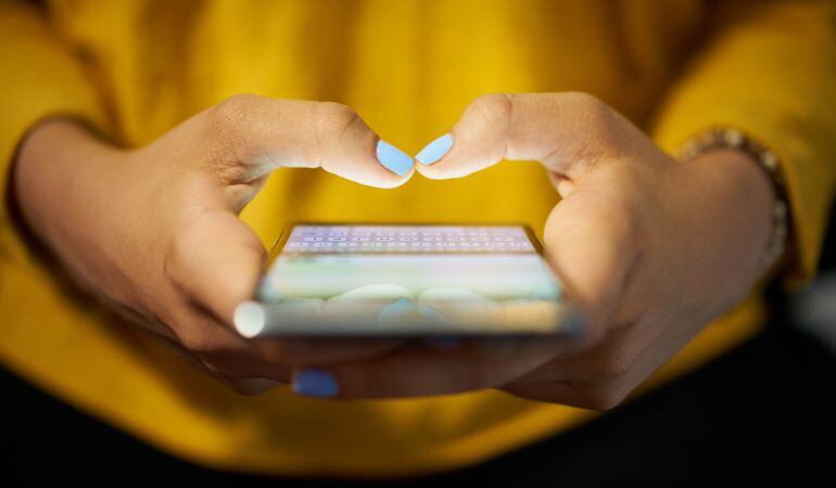 Una mujer utilizando su teléfono móvil.