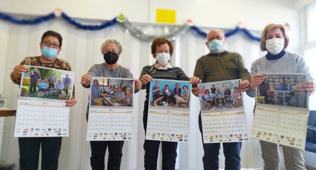 Usuarios de AFA mostrando el calendario solidario 2022 de AFA