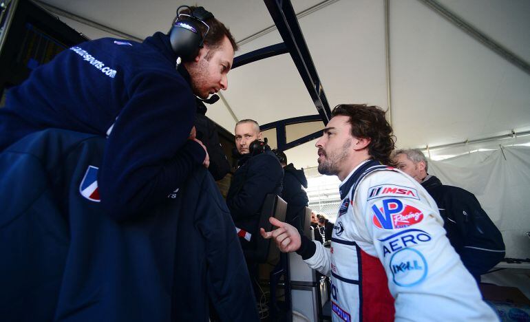 Fernando Alonso habla con miembros de su equipo técnico después de las prácticas para la competencia Rolex 24 Horas 