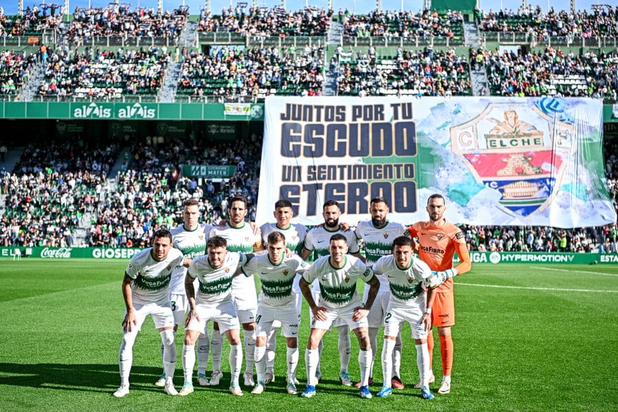 El once titular del Elche y detrás el espectacular tifo de la Federación de Peñas del Club ilicitano