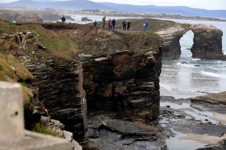 Varias personas en lo alto de un acantilado junto a la playa de las Catedrales (Ribadeo)