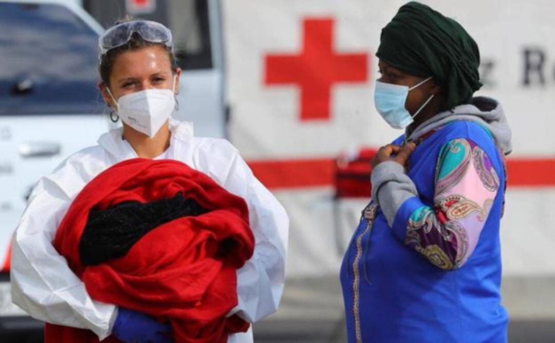 Una sanitaria lleva en brazos al recién nacido al llegar al muelle de Arguineguín