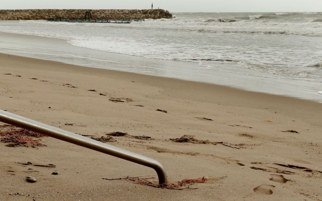 La barandilla de acceso a la playa de El Perelló (València) completamente enterrada en la arena tras el paso de la borrasca &quot;Gloria&quot; que a causado inumerables destrozos en la costa Medirerránea