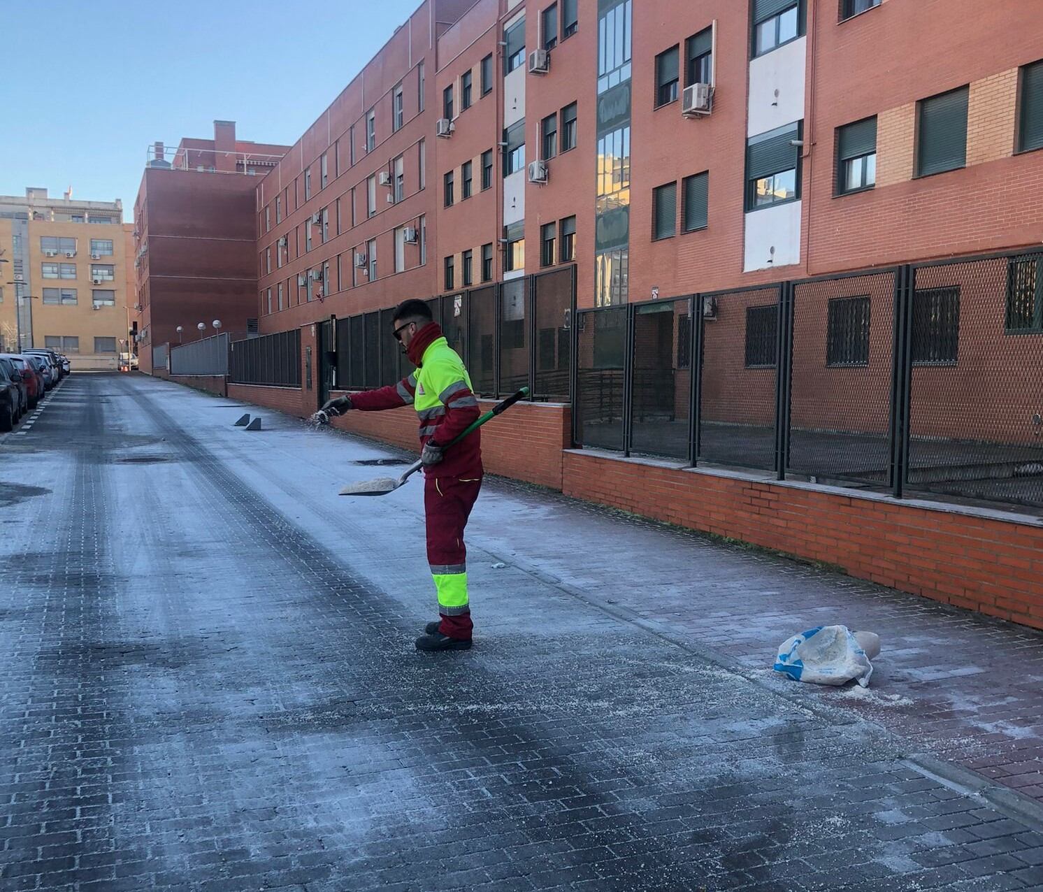 Trabajador repartiendo sal en las aceras de una calle de Móstoles