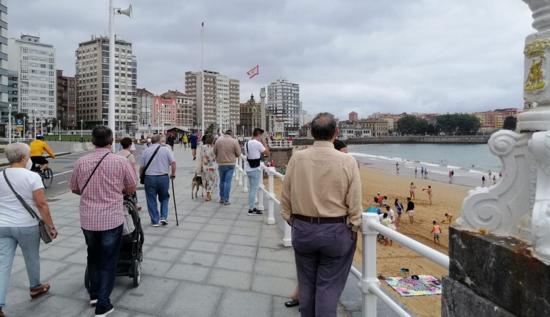 Paseantes y bañistas en la playa de San Lorenzo.