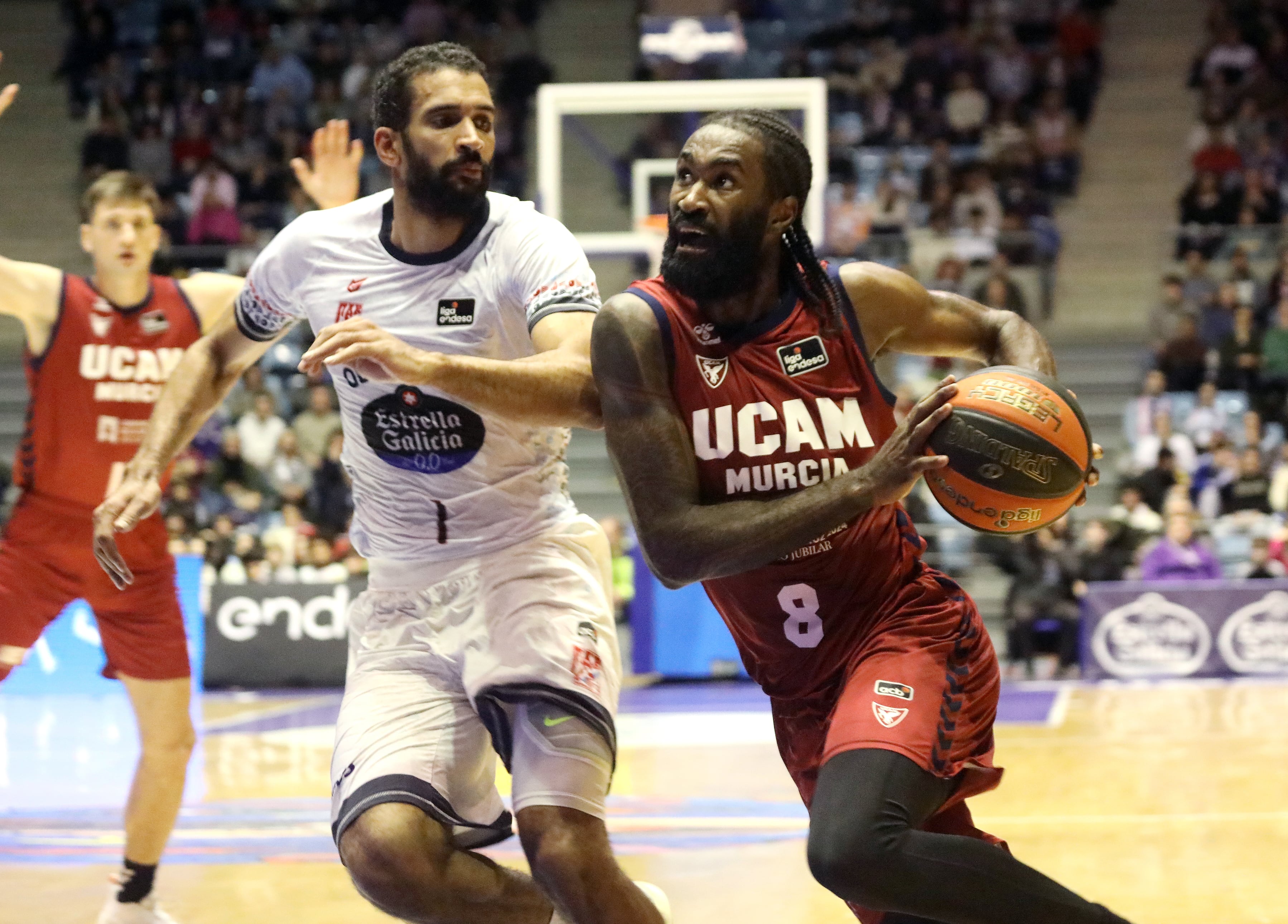 Santiago de Compostela. 29/12/2023. El jugador del Ucam Murcia, Howard San-Roos (d), busca la canasta ante el jugador del Obradoiro, Thomas Scrubb, durante el encuentro correspondiente a la fase regular de la Liga Endesa disputado hoy viernes en el Multiusos de Sar de Santiago de Compostela. EFE / Xoán Rey.
