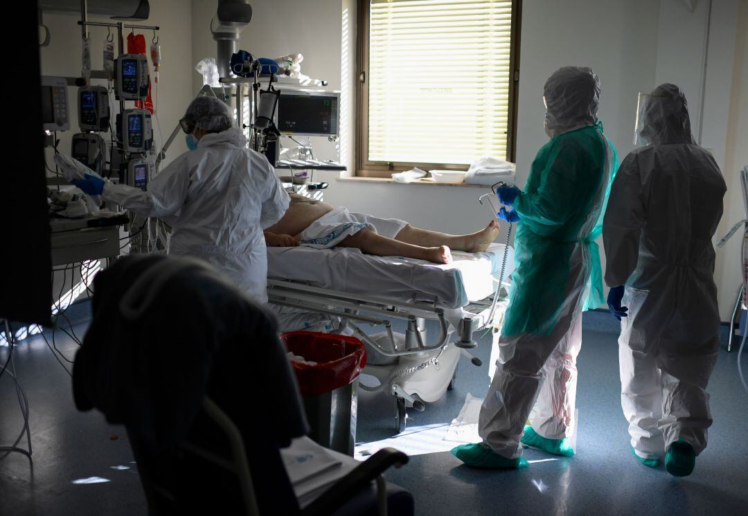 Personal sanitario con un paciente de COVID-19 en la UCI.