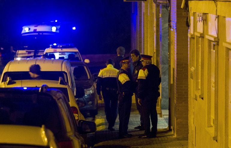 Agentes de los Mossos de Escuadra custodian la puerta de la casa de la calle Nápoles de Terrassa donde dos personas han muerto en un tiroteo. La hipótesis con la que trabajan los Moss es que una o varias personas entraron en la vivienda y dispararon a las