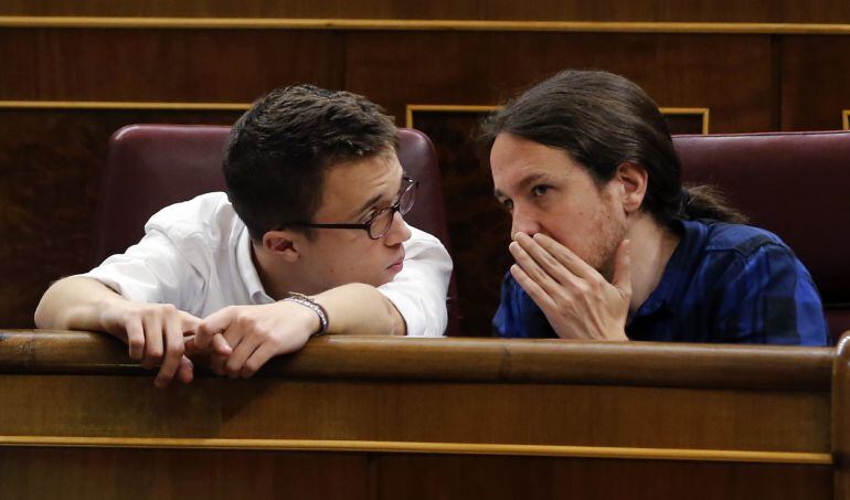 El líder de Podemos, Pablo Iglesias (d), conversa con el portavoz parlamentario, Íñigo Errejón (i), durante el pleno del Congreso