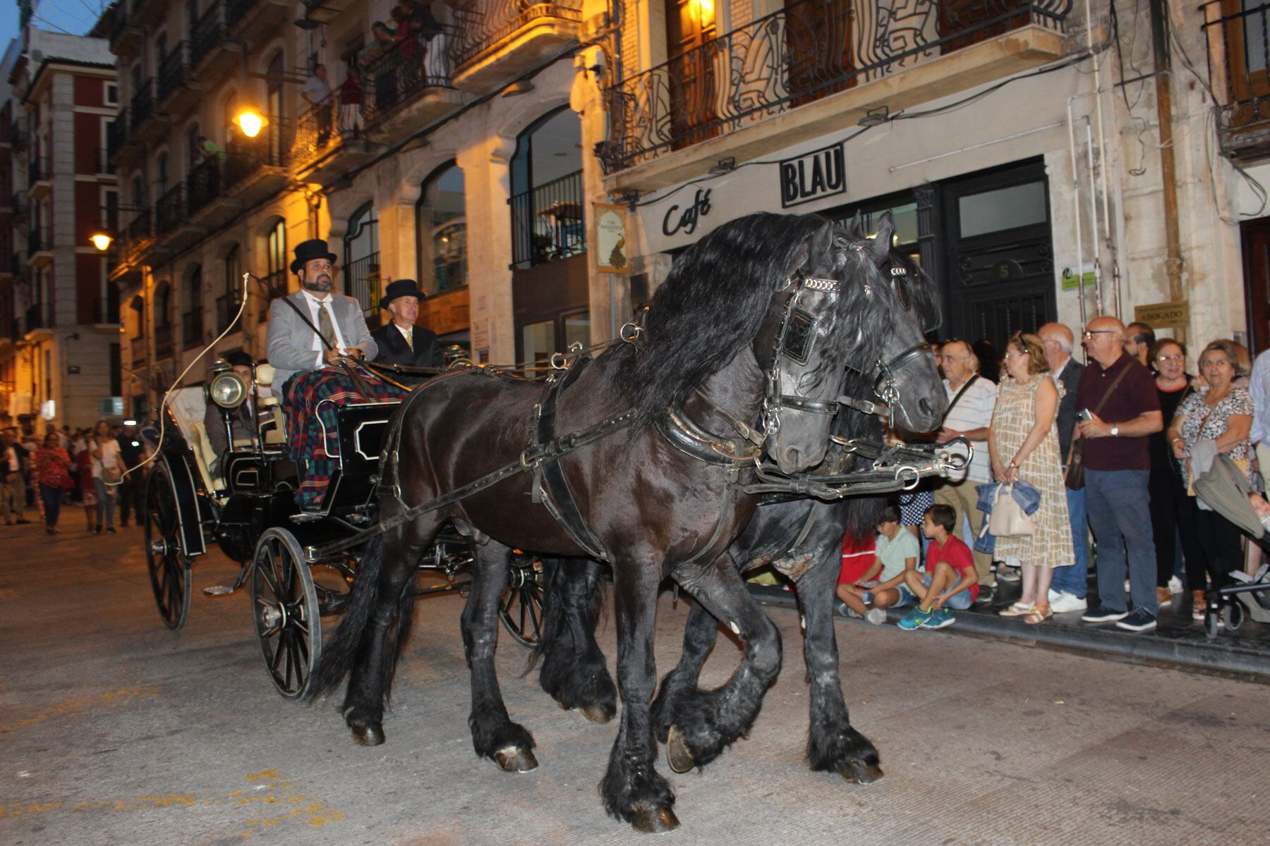Un carruaje tirado por dos espléndidos caballos negros cerraba el desfile