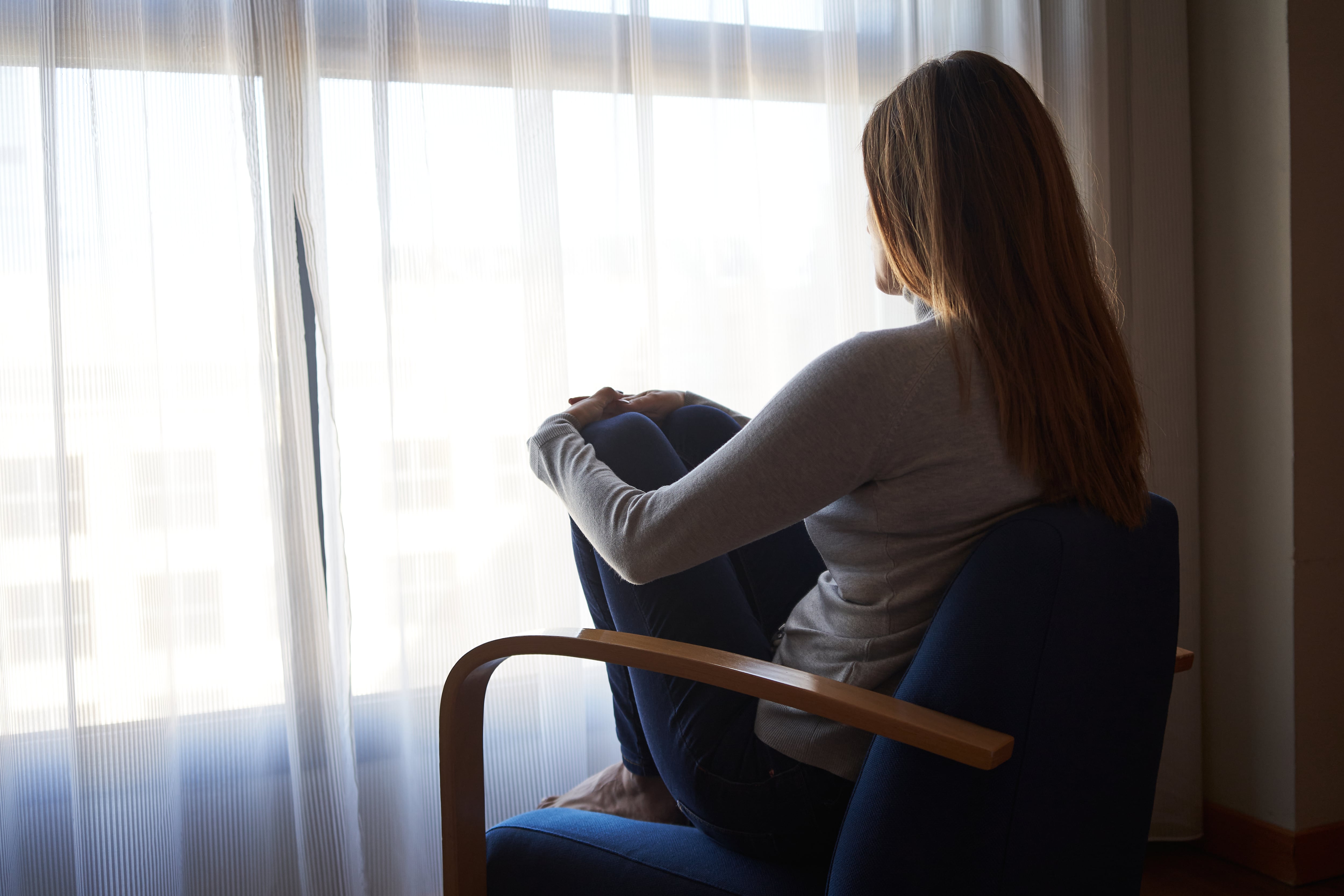 Una mujer mira por la ventana