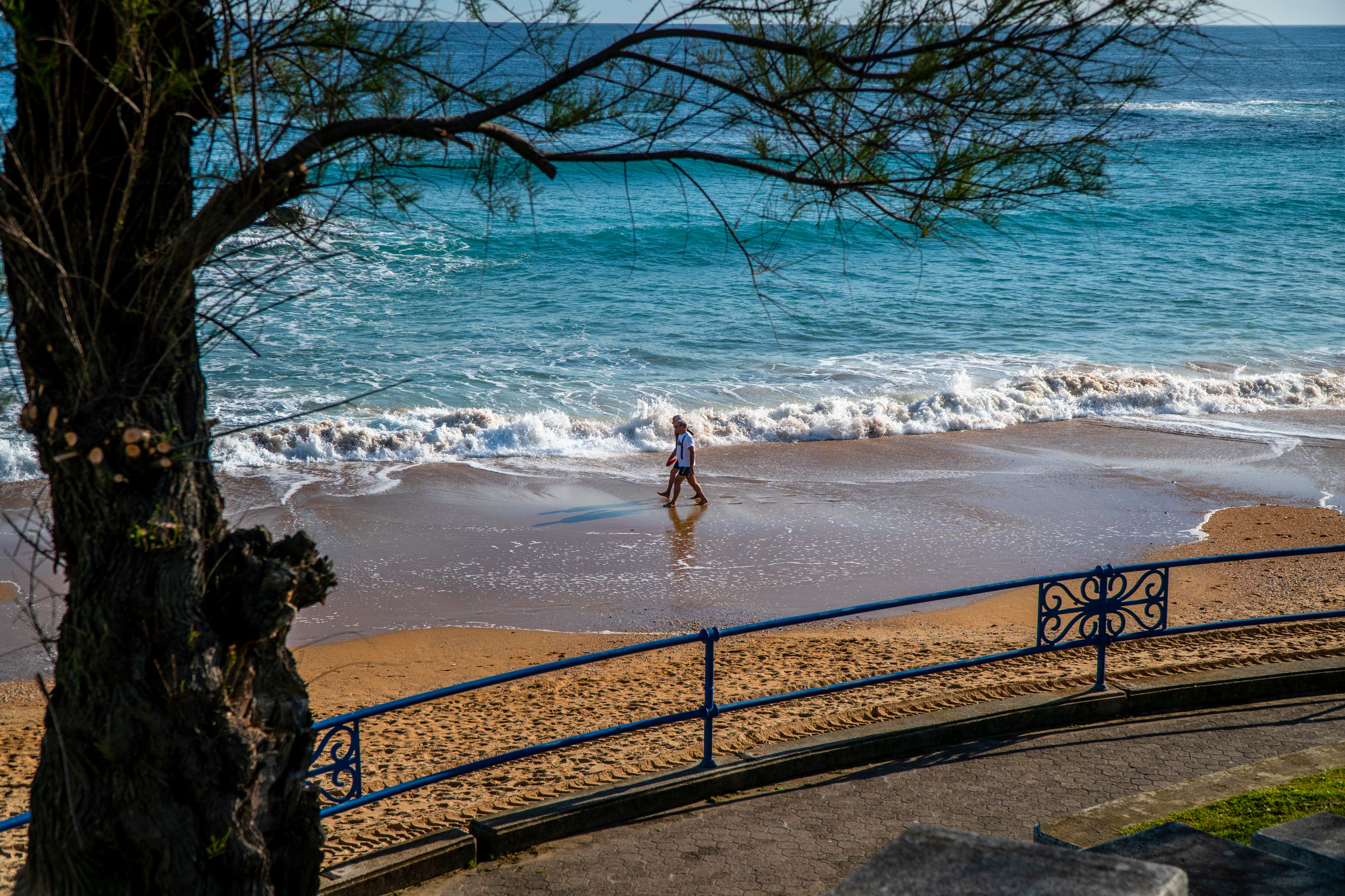 Una persona camina por la playa del Sardinero, en Santander.