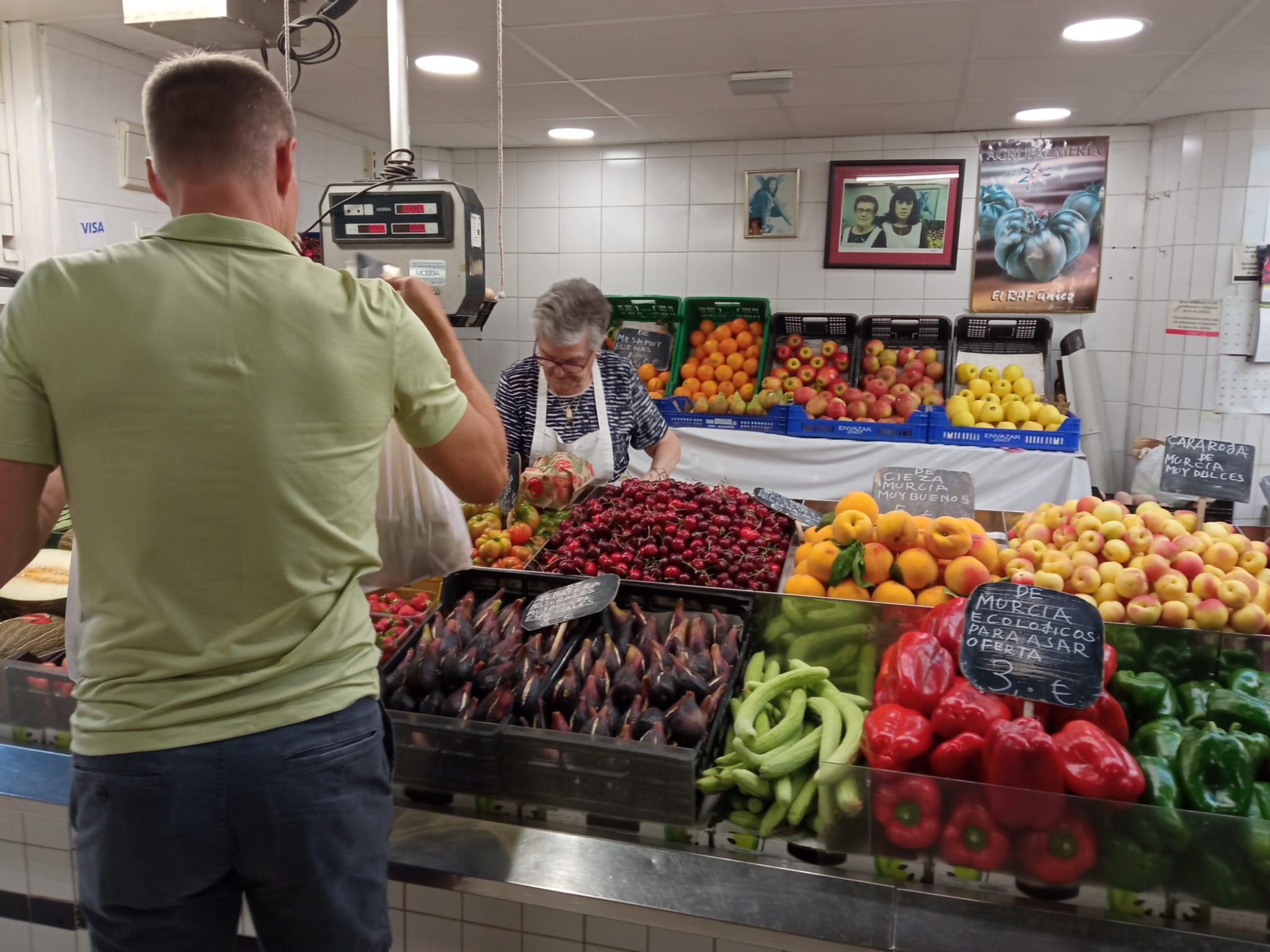 Un cliente compra brevas en una frutería del Mercado Central de Alicante.