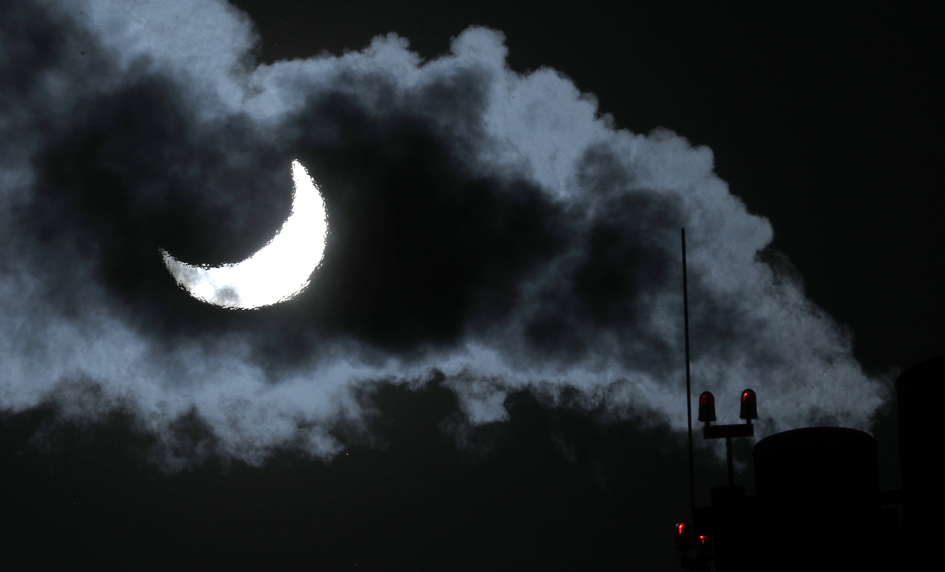 El humo sale de la chimenea de una caldera de gas en Moscú durante el eclipse.