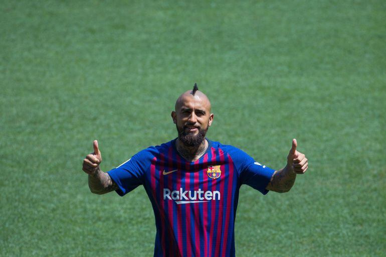 Vidal sonríe con su nueva camiseta en el césped del Camp Nou