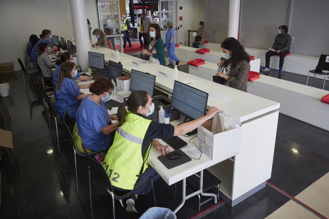 Trabajadores sanitarios protegidos atienden a los pacientes que acude para realizarse una extracción de muestras en el recinto ferial REFENA de Pamplona.