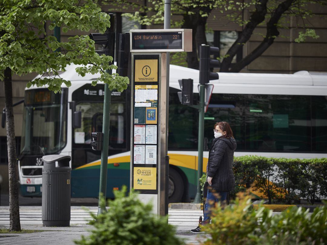 Una mujer camina con mascarilla por la Avenida Carlos III, vacía durante el día en el que se reactiva la actividad laboral no esencial en las empresas cuyos empleados no puedan teletrabajar cuando se cumple un mes desde el inicio del estado de alarma decretado a consecuencia del coronavirus, en Pamplona