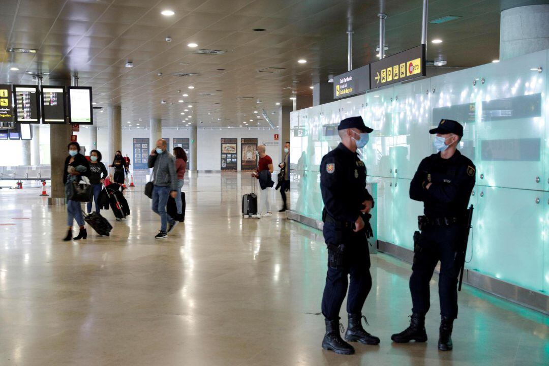 Dos agentes de la Policia Nacional vigilan la puerta de llegadas del aeropuerto de València