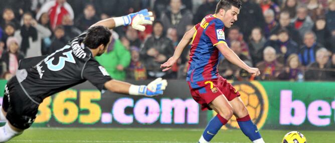 El delantero del FC Barcelona David Villa (d) marca ante el portero del Málaga CF Sergio Asenjo su segundo gol, cuarto de su equipo, durante el partido correspondiente a la decimonovena jornada del Campeonato Nacional de Liga de Primera División que enfre