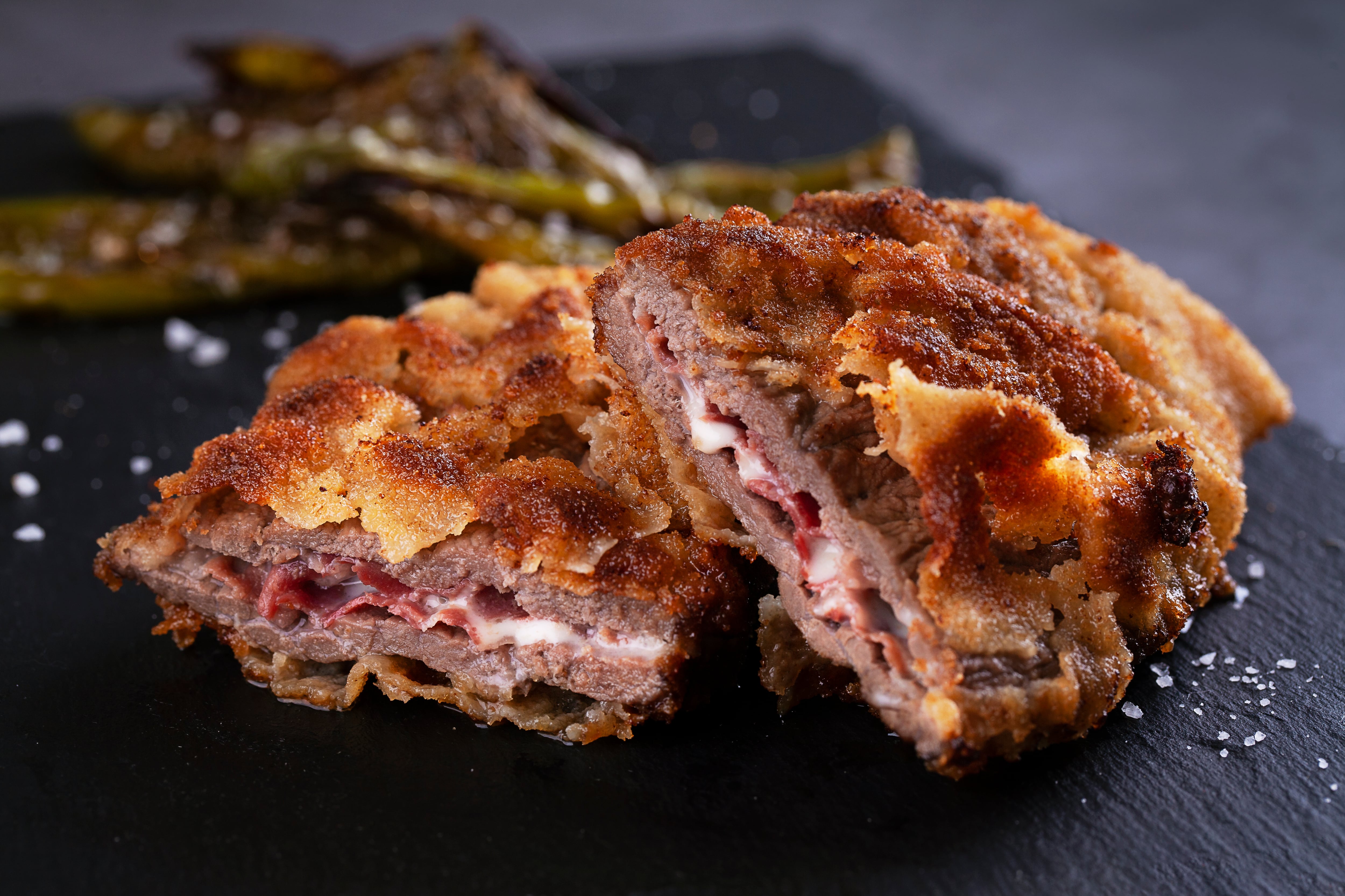 Typical asturian dish, beef cachopo, breaded steak with serrano ham and cheese