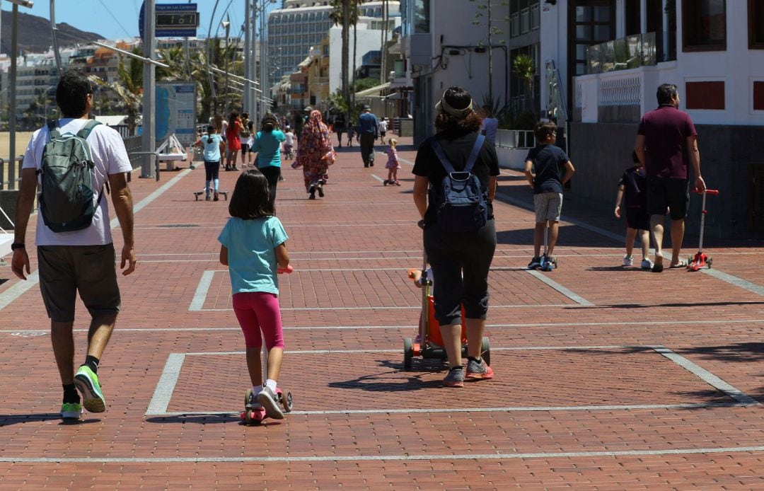 Niños y padres pasean por la avenida de la playa de Las Canteras, en Las Palmas de Gran Canaria este domingo