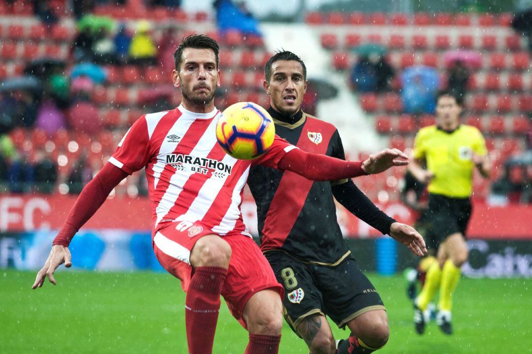 El defensa del Girona, Pedro Alcalá y el centrocampista del Rayo, Oscar Trejodurante el partido de la décima jornada de Liga que disputan en el Campo Municipal Montillivi.