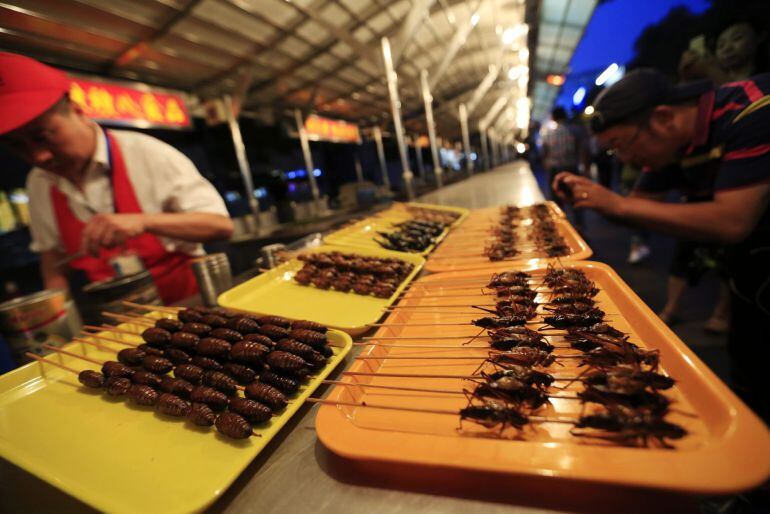 Vista de pinchos de escorpiones, grillos, cigarras y otros bichos disponibles en el puesto del vendedor Zheng Zhongbin en el mercado nocturno de Donghuamen.