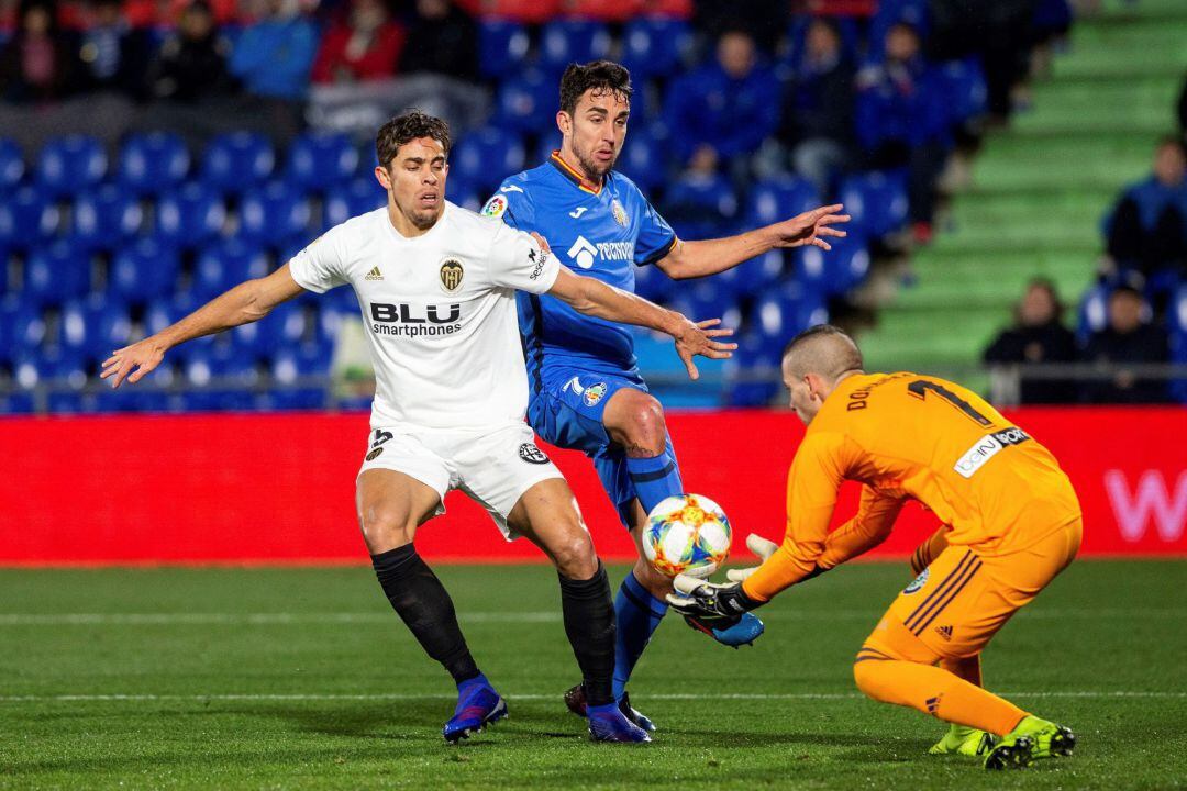 GRAF3156. GETAFE (MADRID), El delantero del Getafe CF Jaime Mata (c) lucha con el brasileño Gabriel Paulista (i) y el portero Jaume Doménech, ambos del Valencia CF, durante el partido de ida de cuartos de final de la Copa del Rey que se disputa esta noche en el Coliseo Alfonso Pérez de Getafe. EFE, Rodrigo Jiménez