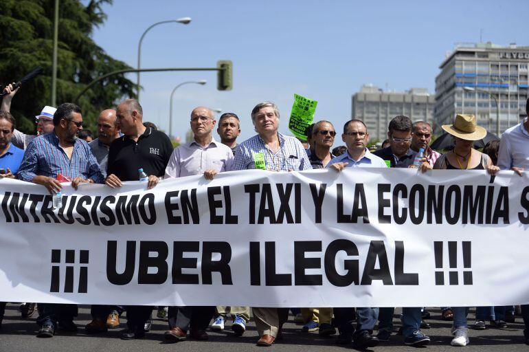 (FILES) A file picture taken on June 11, 2014 shows taxi drivers carrying a banner during a strike action in protest of unliscensed taxi-type-services in central Madrid. A judge on December 9, 2014 banned the popular US cellphone-based taxi service Uber f