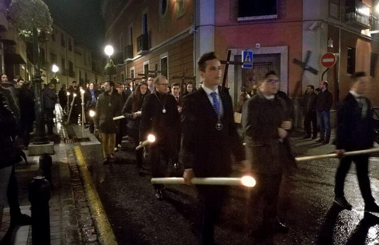 Cortejo del vía crucis oficial con el asfalto mojado por la aplicación del líquido que permitirá retirar más fácilmente la cera