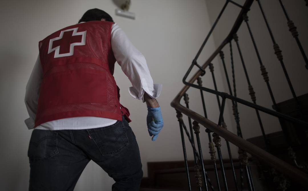 Un miembro de Cruz Roja acudiendo a un piso de acogida