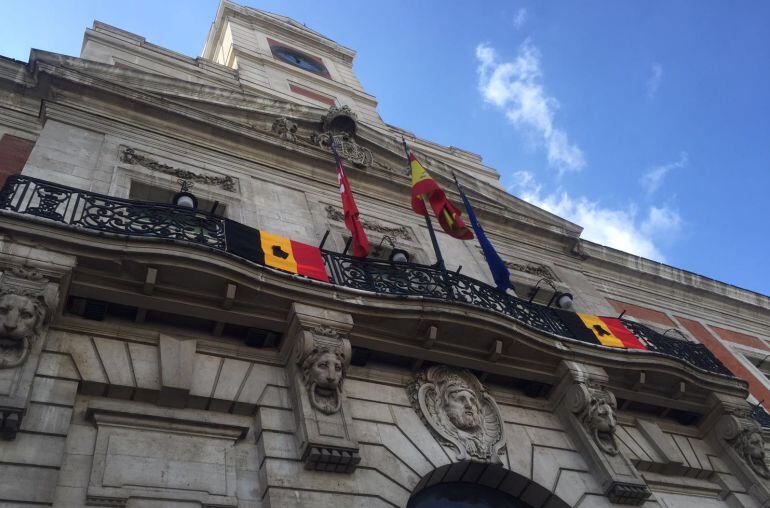 Banderas belgas con crespones negros en la Puerta del Sol