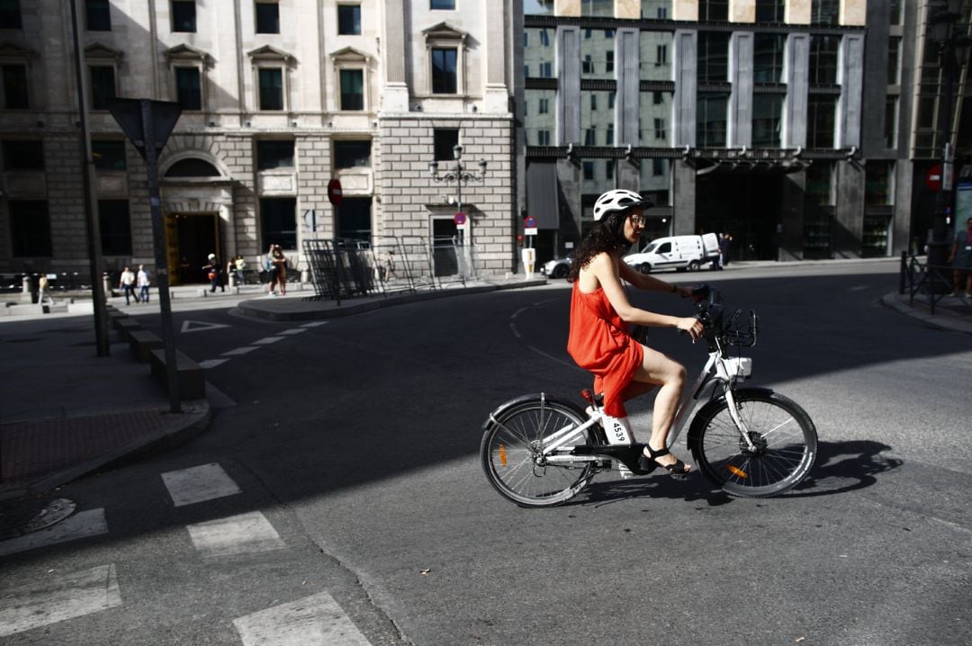 Una ciclista pasea con una bicicleta eléctrica cerca del Congreso de los Diputados. Archivo.