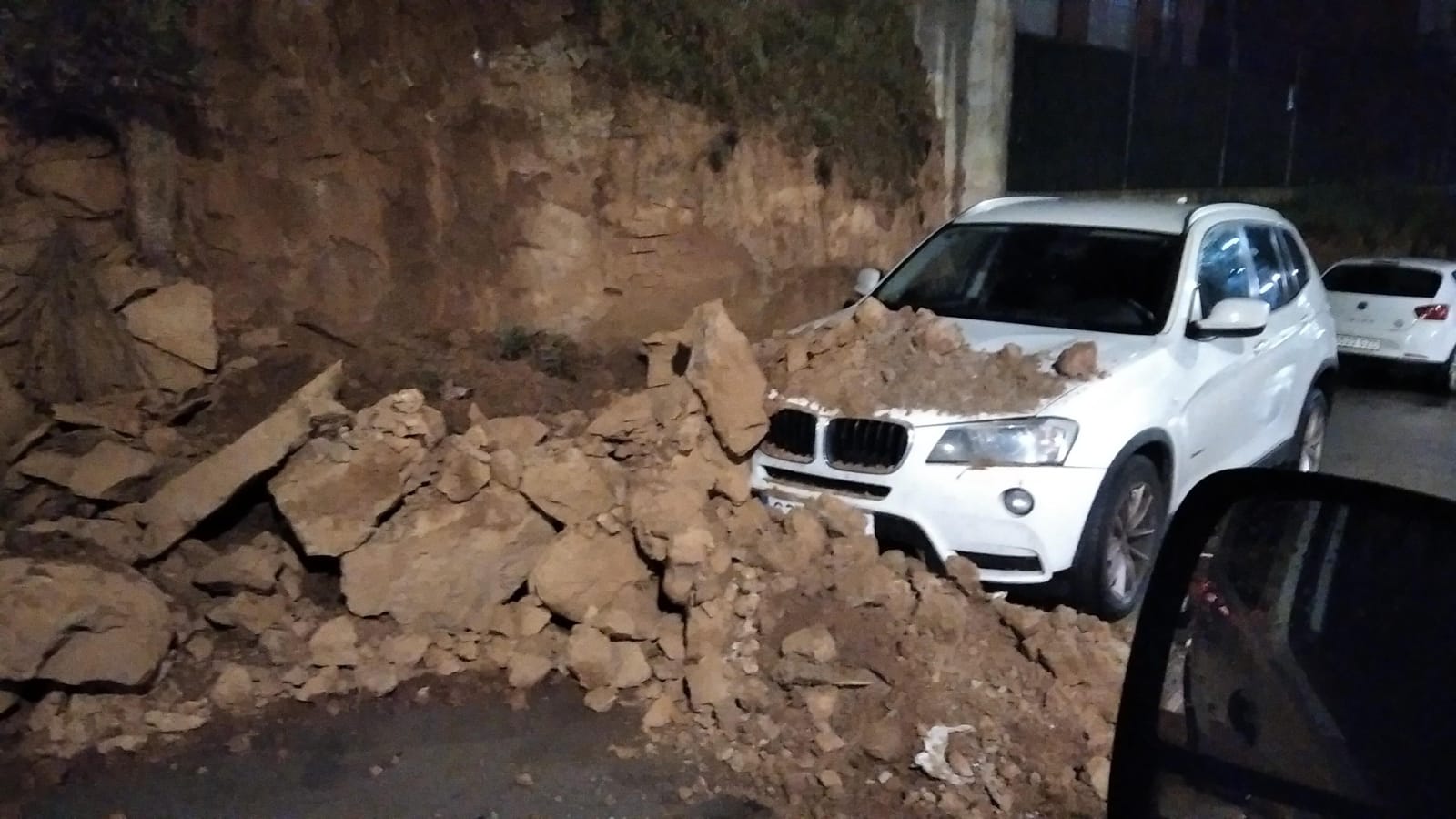Derrumbe de parte del talud sobre un vehículo
