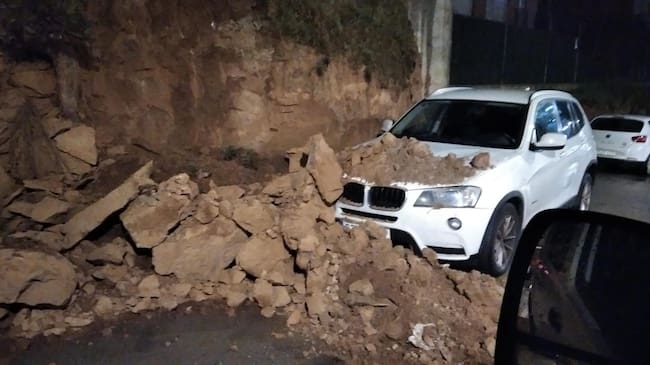 Derrumbe de parte del talud sobre un vehículo