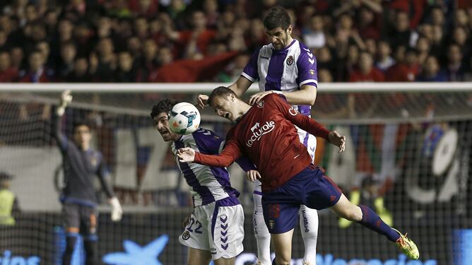 Oriol Riera pugna un balón aéreo con Mitrovic y Víctor Pérez.