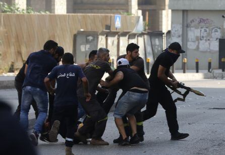 Un manifestante del movimiento chií de Hezbolá y Amal recibe ayuda después de ser herido cerca del Palacio de Justicia en Beirut.