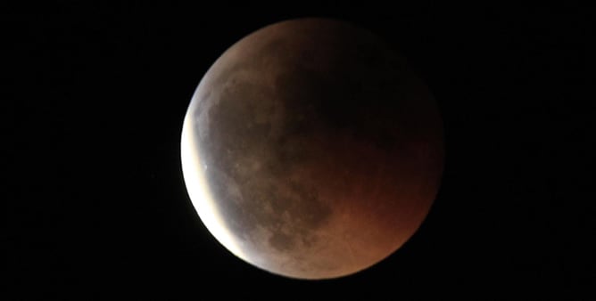 La luna durante el eclipse que ha tenido lugar esta noche, el más largo desde el año 2000, visto desde la sierra madrileña en las proximidades de El Escorial