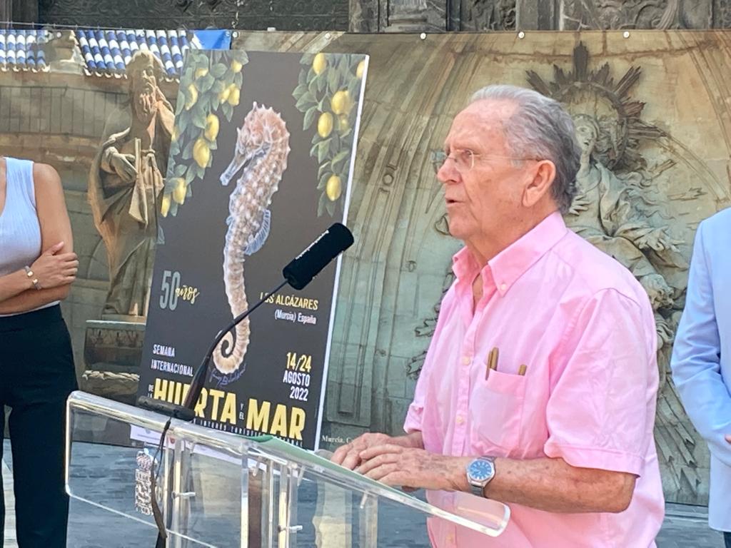 El pintor, Manuel Gómez Balsalobre, habla junto al cartel anunciador de este año