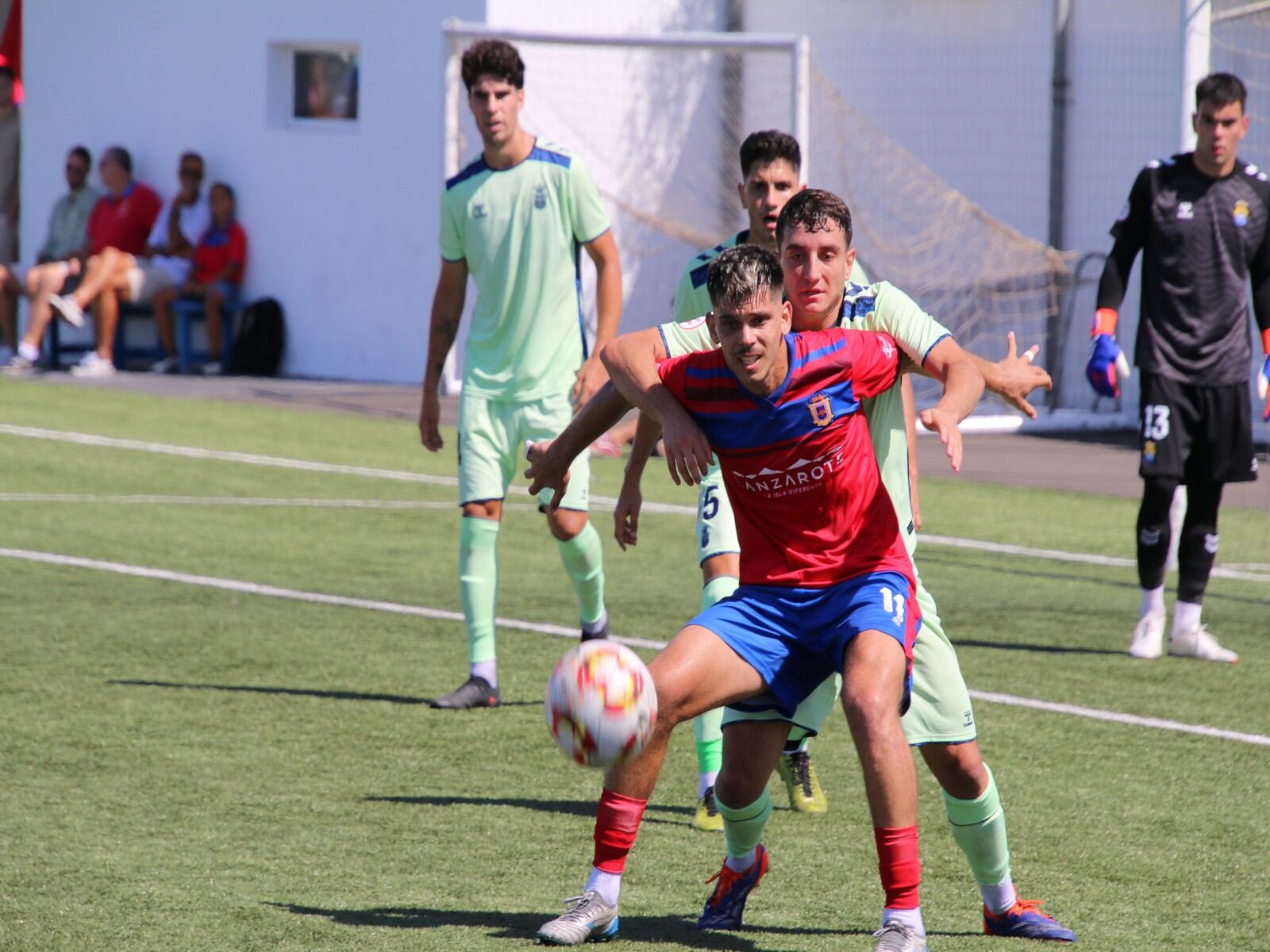 Pelea por el balón entre jugadores de la UD Lanzarote y la UD Las Palmas Atlético.