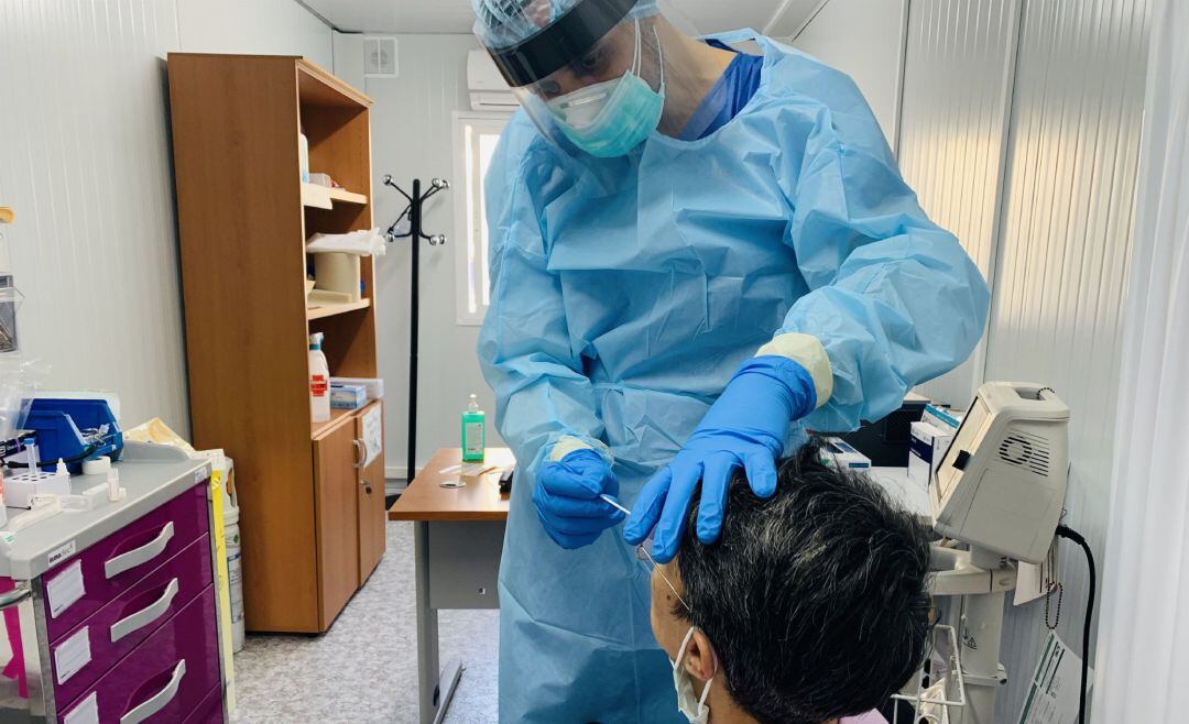 Un sanitario realiza una PCR en un hospital