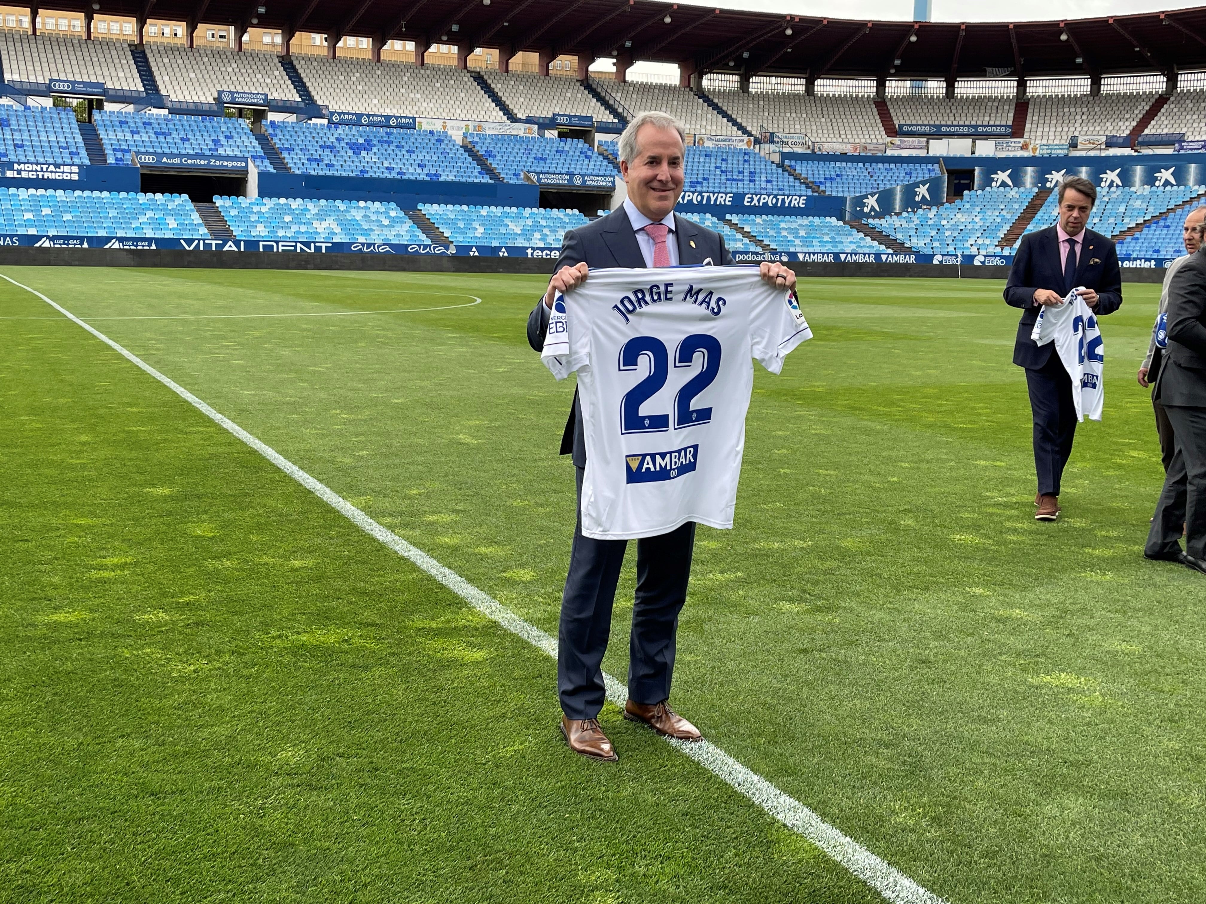 Jorge Mas posa con una camiseta del Real Zaragoza sobre el césped de La Romareda