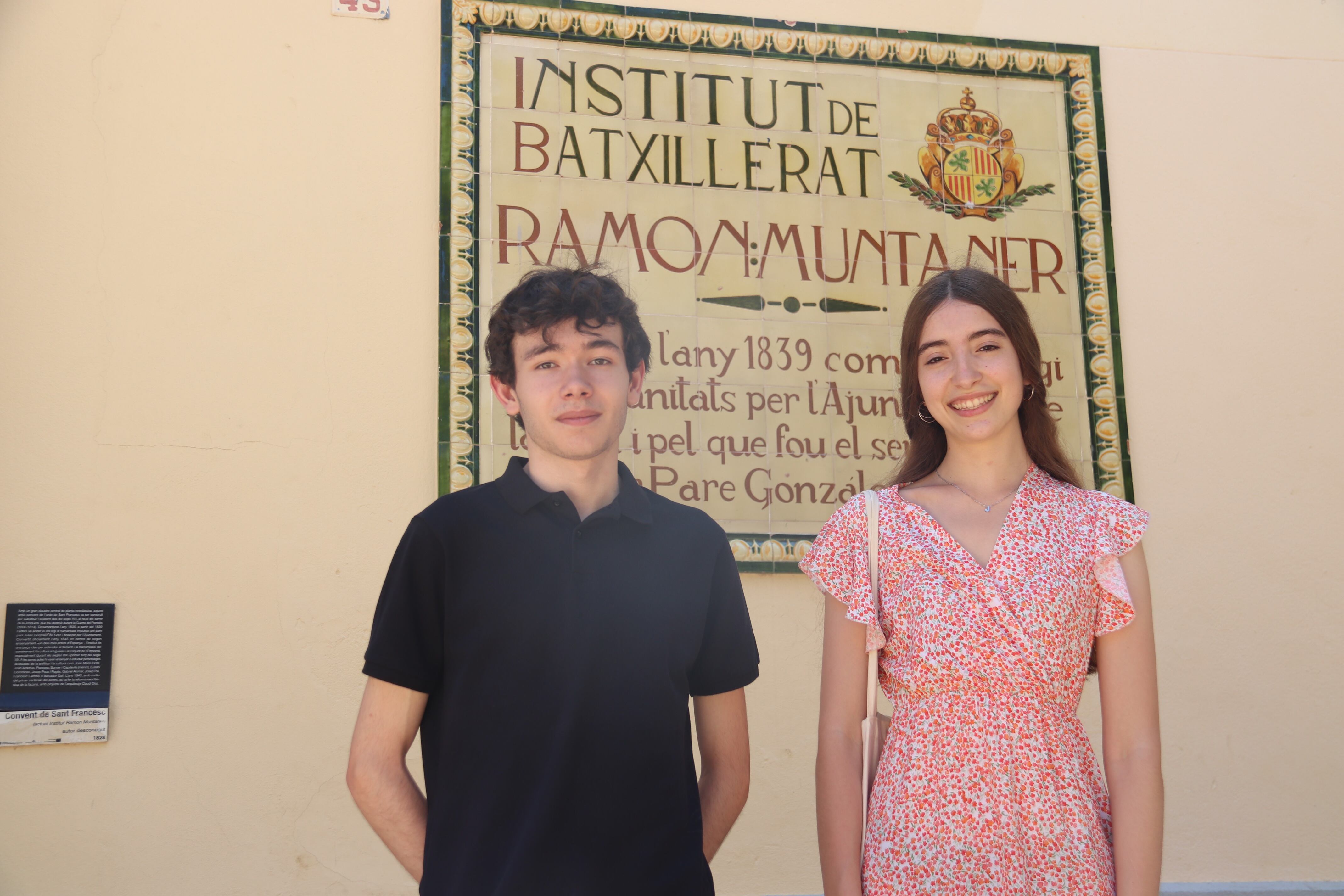 Els dos estudiants amb més nota de les PAU a Girona, Júlia Fita i Blai Higueras davant de la placa de l’Institut Ramon Muntaner on estudiaven.
