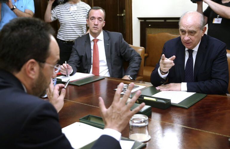 El ministro del Interior, Jorge Fernández Díaz, junto al secretario de Estado de Seguridad, Francisco Martínez, y el portavoz del PSOE en el Congreso, Antonio Hernando.